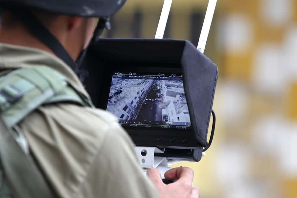 An Israeli soldier uses an unmanned surveillance drone to monitor Palestinians in the occupied West Bank city of Hebron in 2015 (AFP)